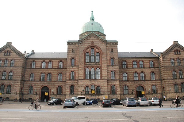 Historic brick building with a dome at the University of Copenhagen, symbolizing its commitment