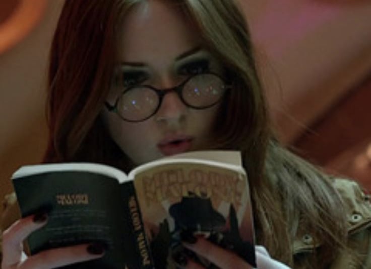 foto da personagem amy pond da serie doctor who lendo um livro dentro da tardis