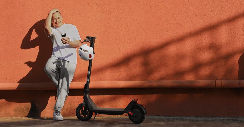 a man leaning against a wall with a scooter