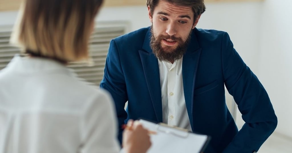 a man and woman in business attire sitting in a meeting room