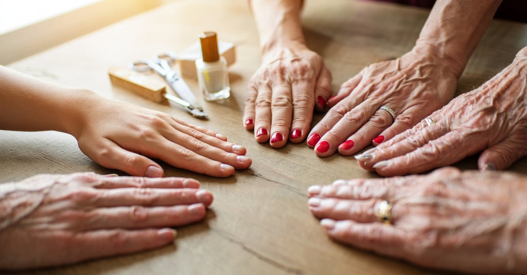 diversi tipi di mani in base all'eta con diversi Tipi di smalto e colori su un tavolo di legno