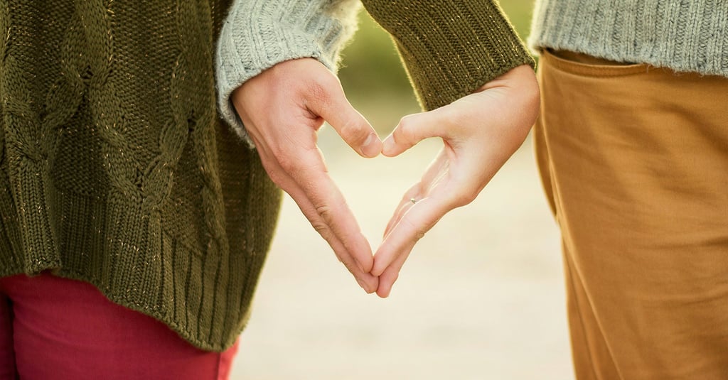 couple qui se tient la main en forme de  coeur