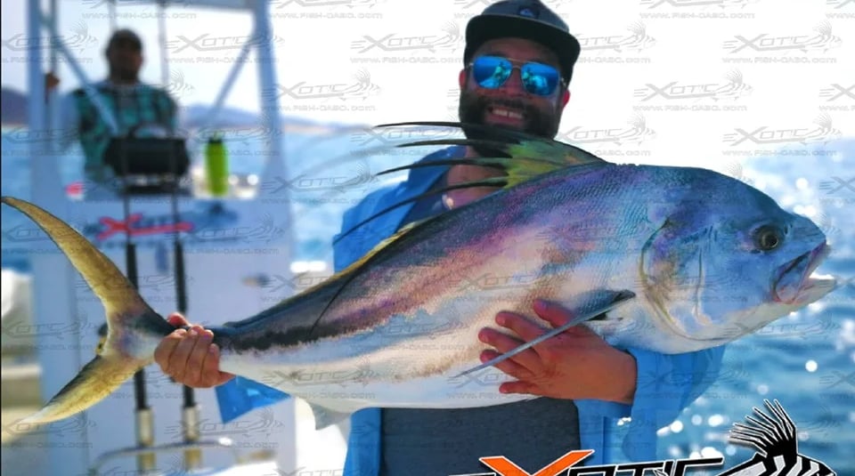 a man holding a fish on a boat