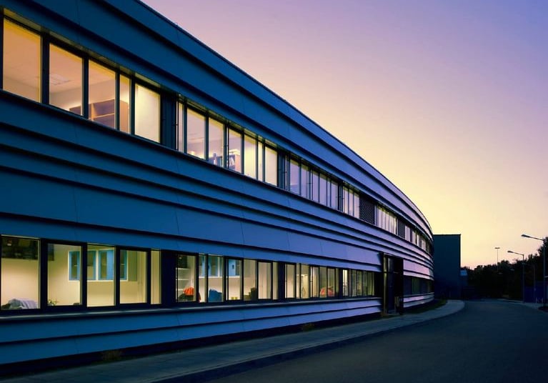 Helmholtz Centre for Environmental Research building at twilight with illuminated windows and orange
