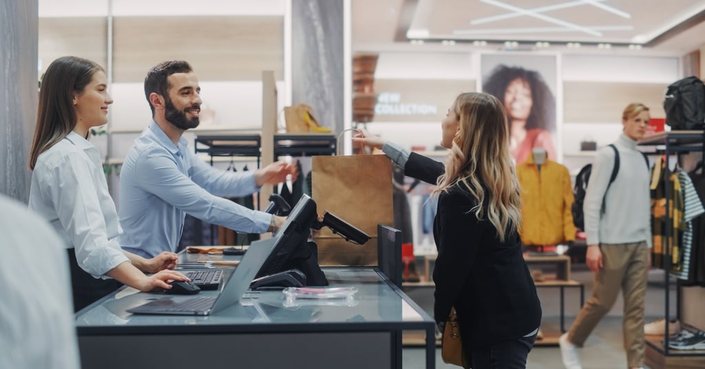 a man and woman serving a customer in a store