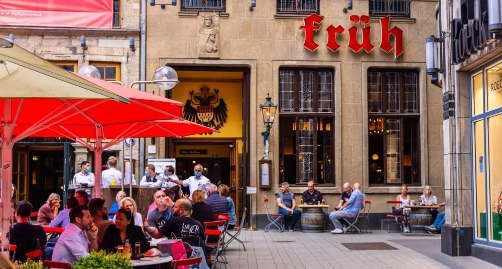 Blick über die Kölner Skyline mit dem Dom im Zentrum, Rhein und urbanen Gebäuden, aufgenommen bei Tageslicht.