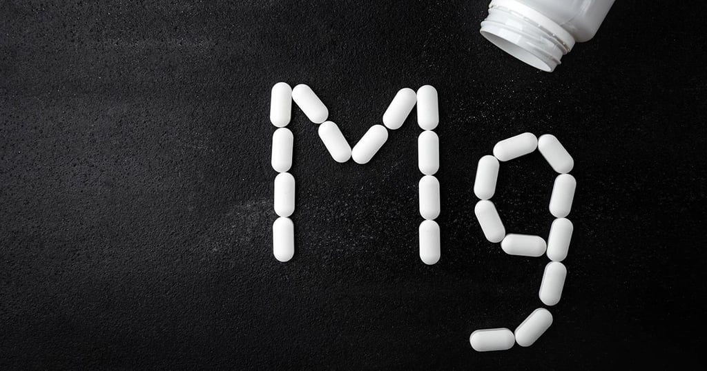 Cápsulas saliendo de un frasco y formando el símbolo química del margnesio