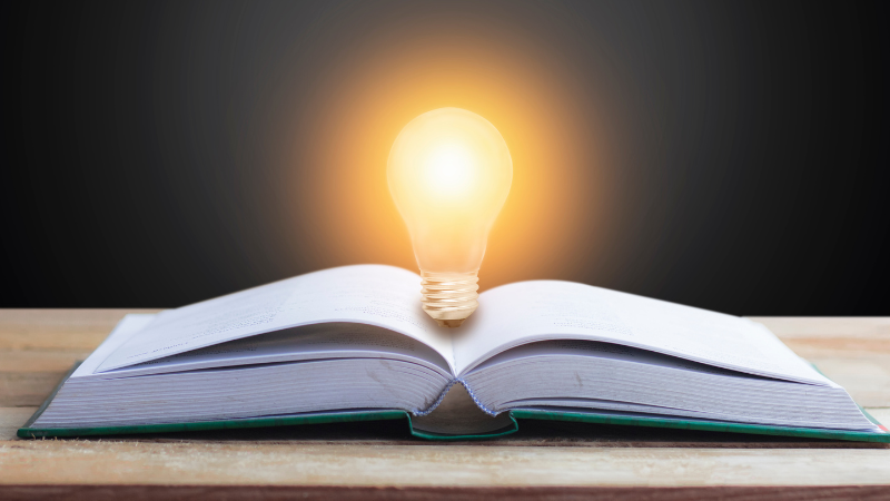 a book open book with a light bulb on top of it