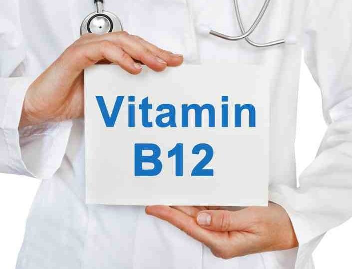 man hodling sign with B12 written on it