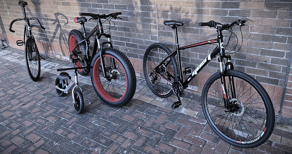 two bikes parked next to each other on a brick wall
