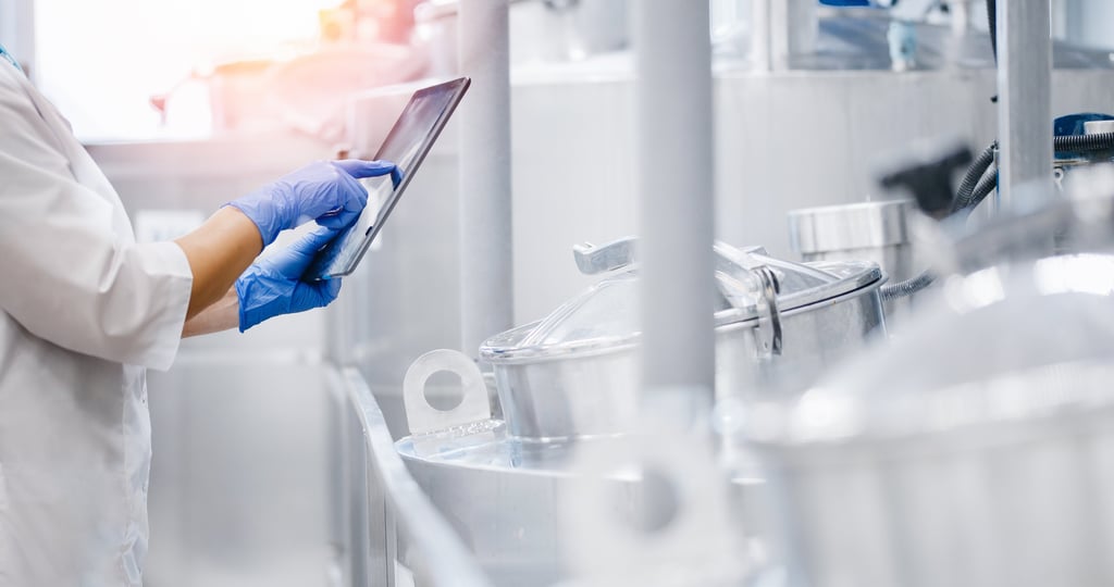 a person in a lab coat and gloves holding a tablet computer