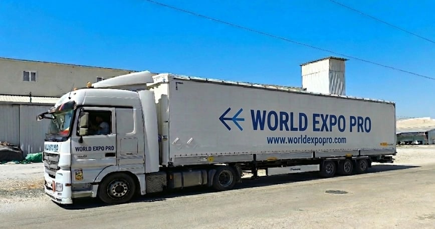 a truck with a world of expo pro truck parked in front of a building