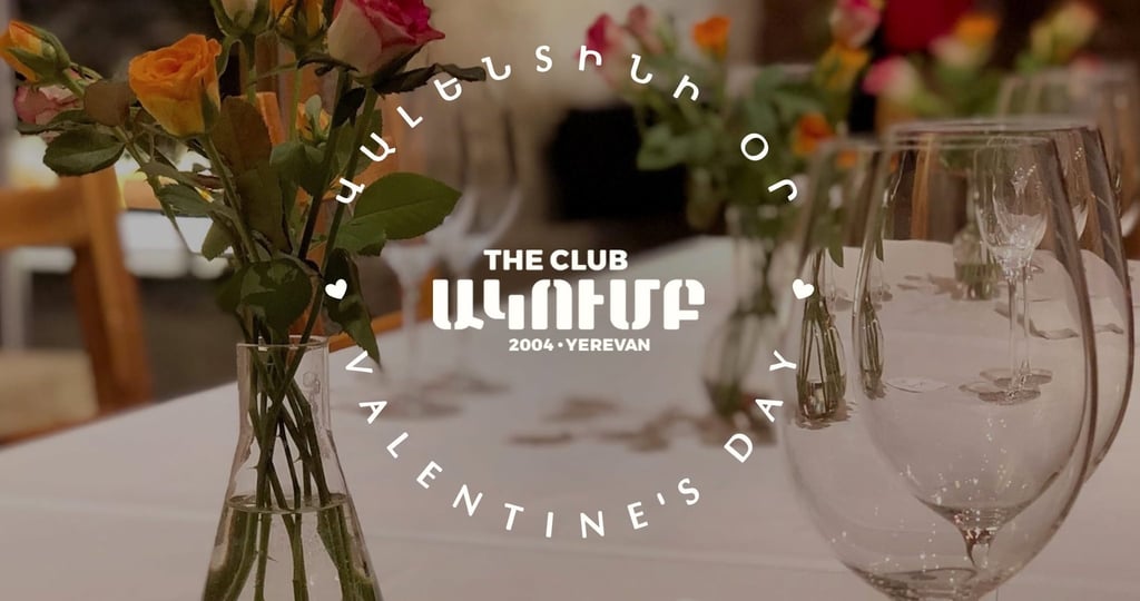 Elegant Valentine's Day dinner table setting at The Club Yerevan with roses and wine glasses.
