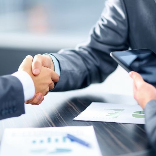 Dois executivos fechando negócios e apertando as mãos .