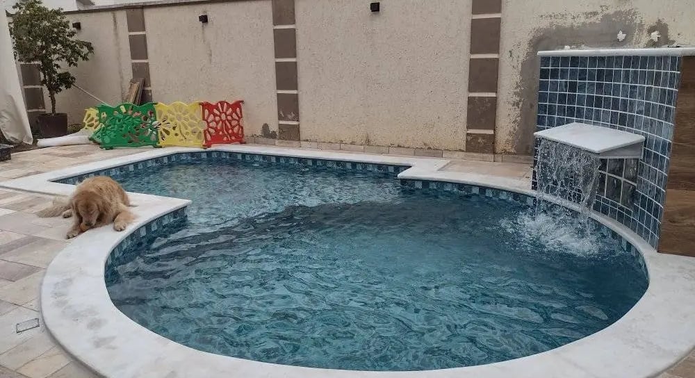 Suasana malam kolam renang air hangat di villa Subang, lampu menyala.