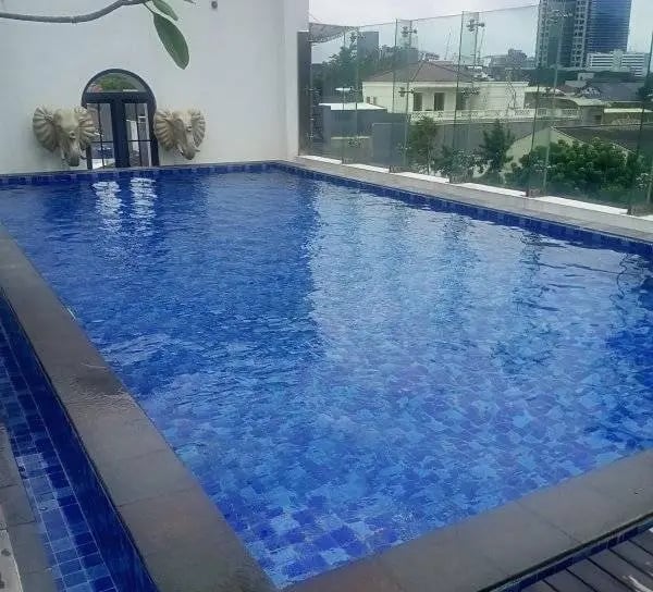 Desain kolam renang air hangat modern dengan air terjun buatan di Indramayu.