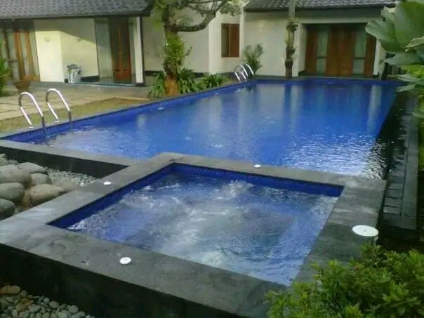 Kolam renang air hangat minimalis dengan dek kayu di halaman belakang rumah Garut