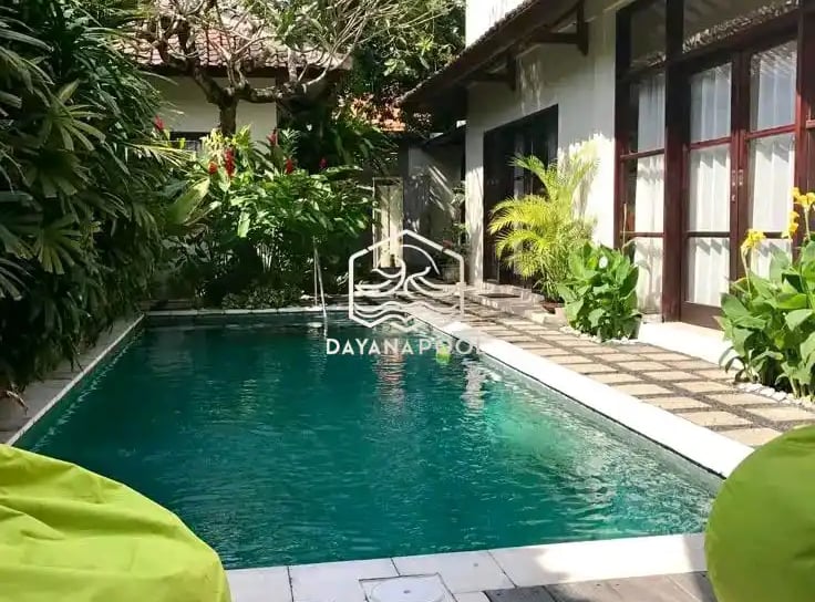 kolam renang minimalis di halamn belakang rumah dengan finishing batu alam