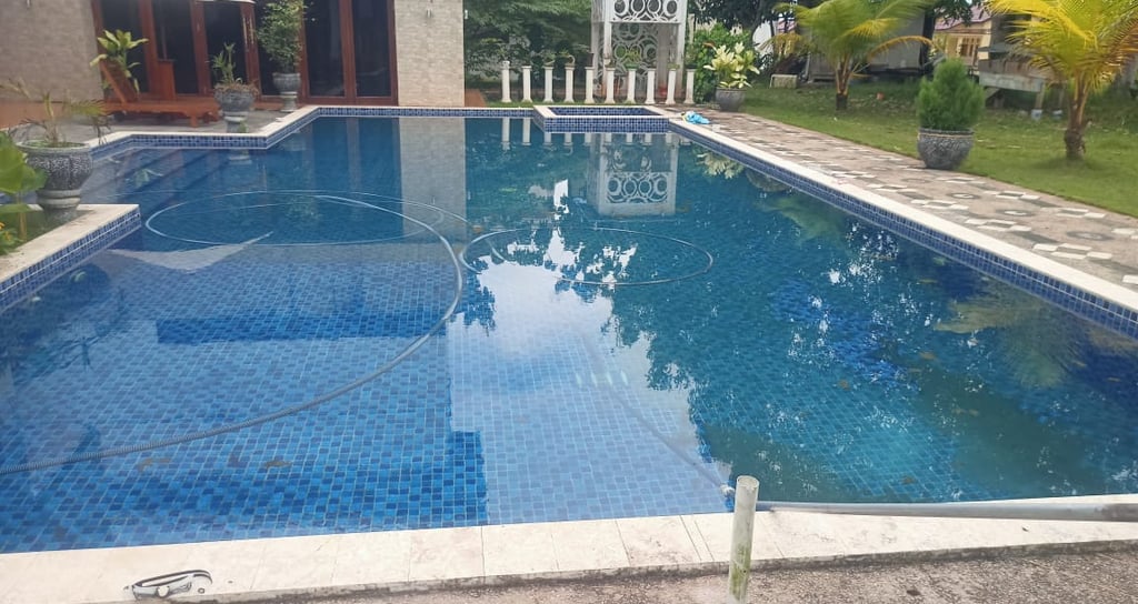 kolam renang yang bermasalah di kualitas airnya, yang timbul lumut di mana-mana.
