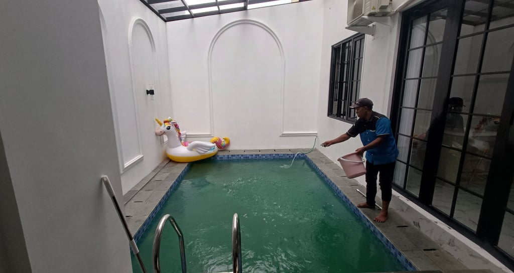 penaburan obat untuk treatmen kolam renang yang airnya sudah hijau