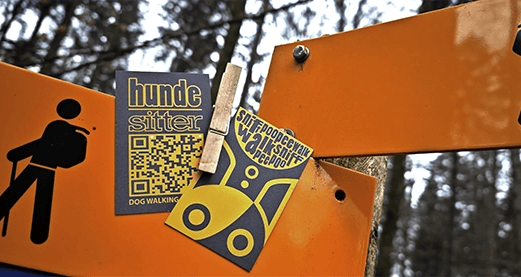 www.hunde-sitter.pro Visitenkarten am Schild im Wald befestigt