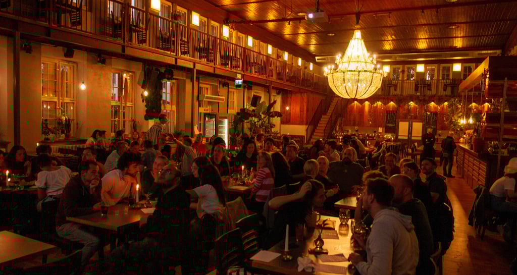 Menschen sitzen in Gruppen beim Quiz in Berlin