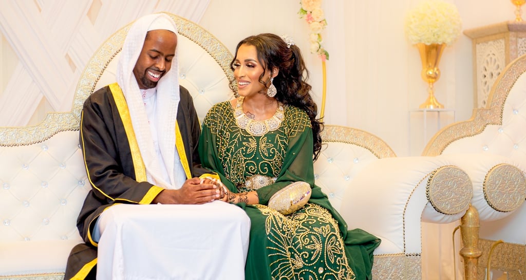 Somalian bride & groom in traditional wedding outfits, sitting & holding both happy, light & airy