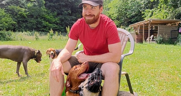 Hundetrainer mit Hund auf dem Schoß, entspannte Atmosphäre in der Hundeschule