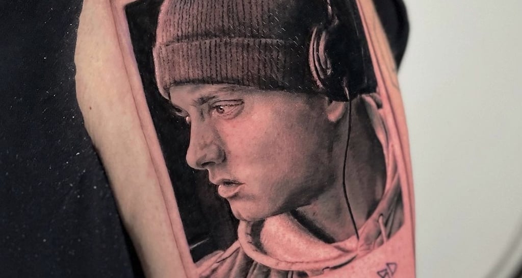 Tatuaggio ritratto in nero e grigio dettagliato di Eminem in una polaroid eseguito da Horidoku 