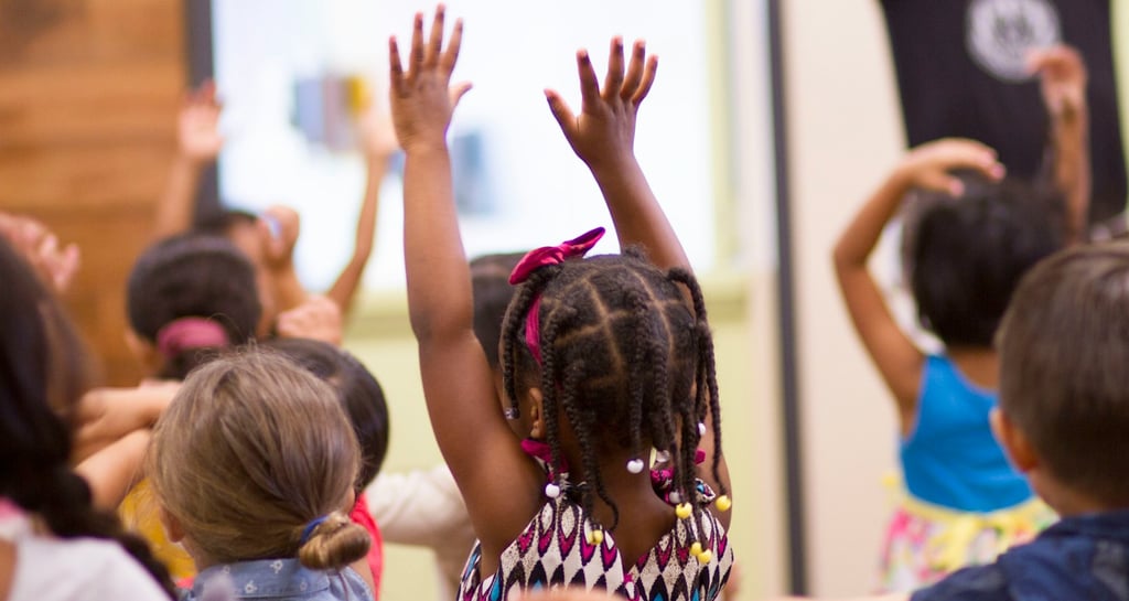 Child hands are raised in children's church.