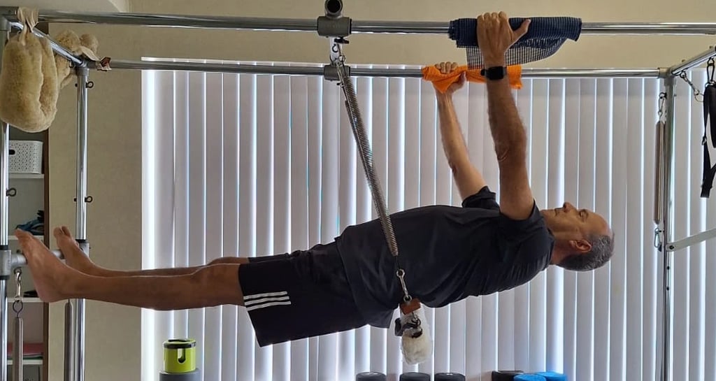 Aluno idoso no aparelho de pilates