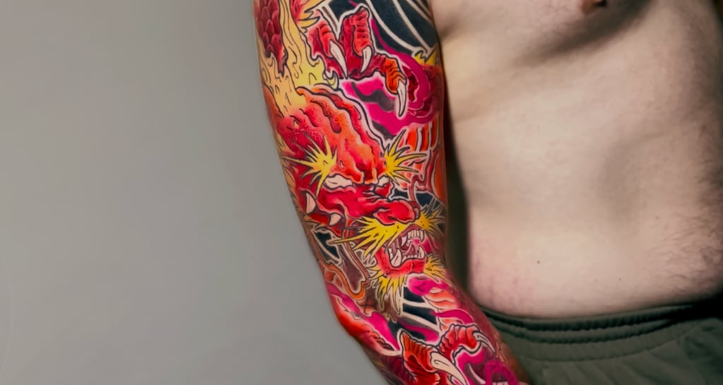 Tatuaggio sul braccio di un drago giapponese rosso e giallo eseguito da Horidoku 