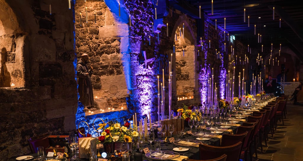 Event venue decorated with tall candles and Harry Potter theme – magical event photography by Fred A