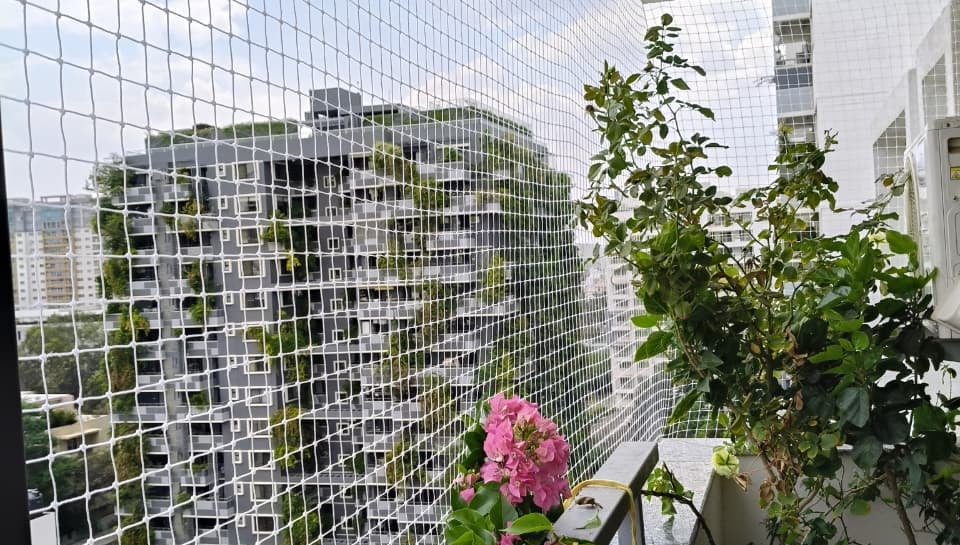 Close-up of a freshly installed balcony safety net on a high-rise apartment in Malleshwaram.