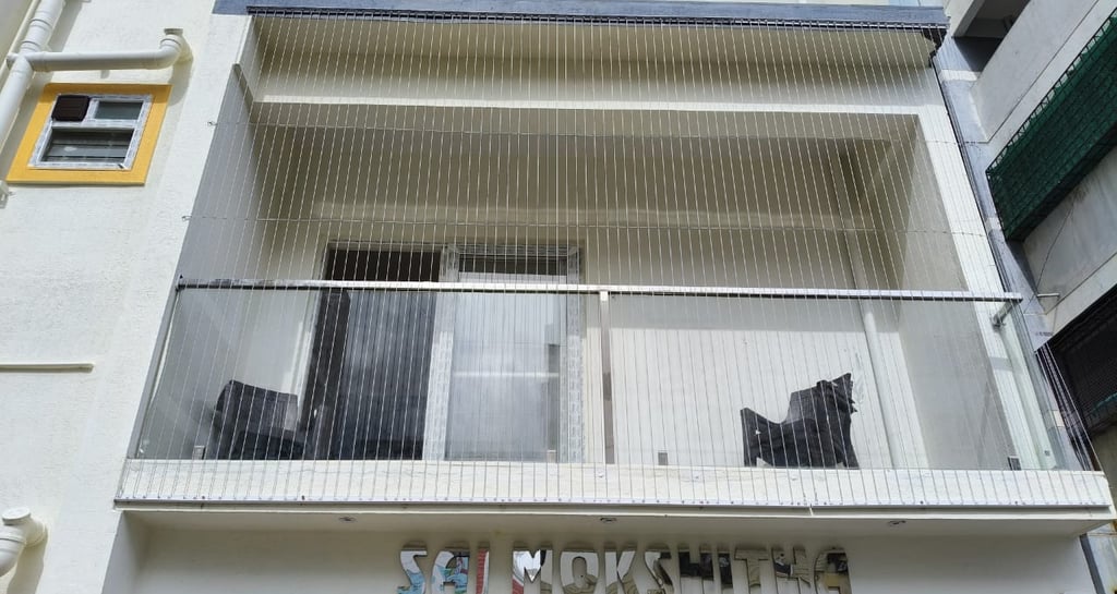 Close-up of a sleek invisible grill seamlessly blending with a balcony window in a Nungambakkam resi