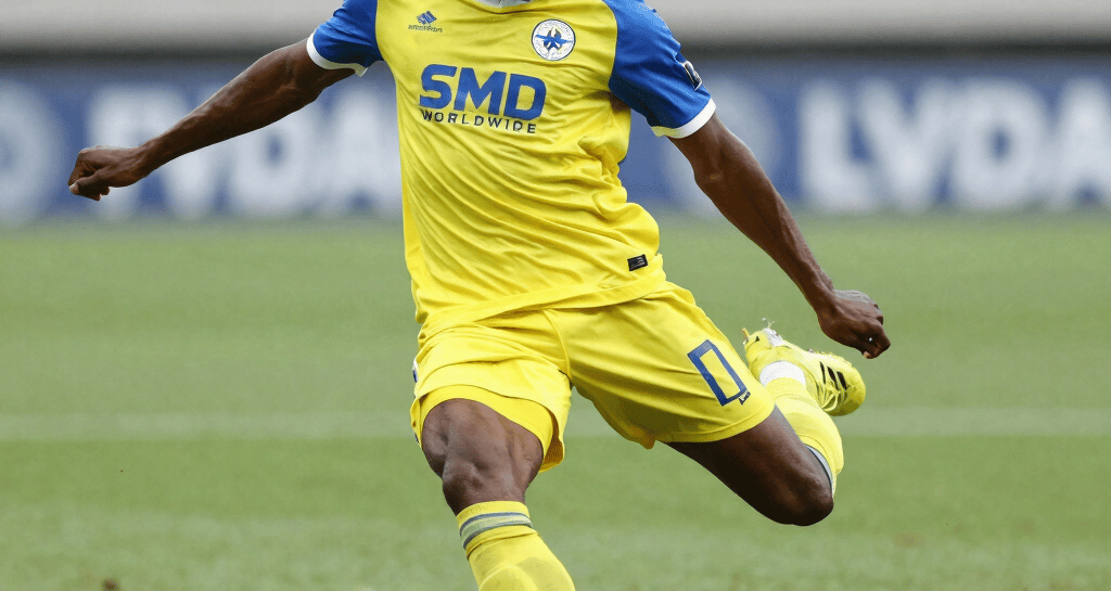Young player focused during a technical dribbling drill on the training pitch.