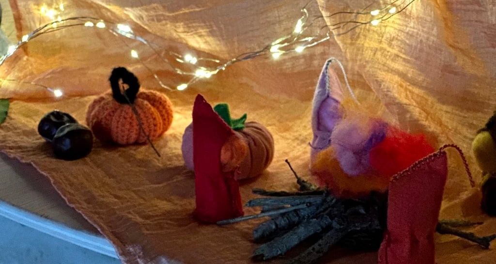 Escena de tardor amb figuretes de tela i llumetes, carbassa de llana i castanyes