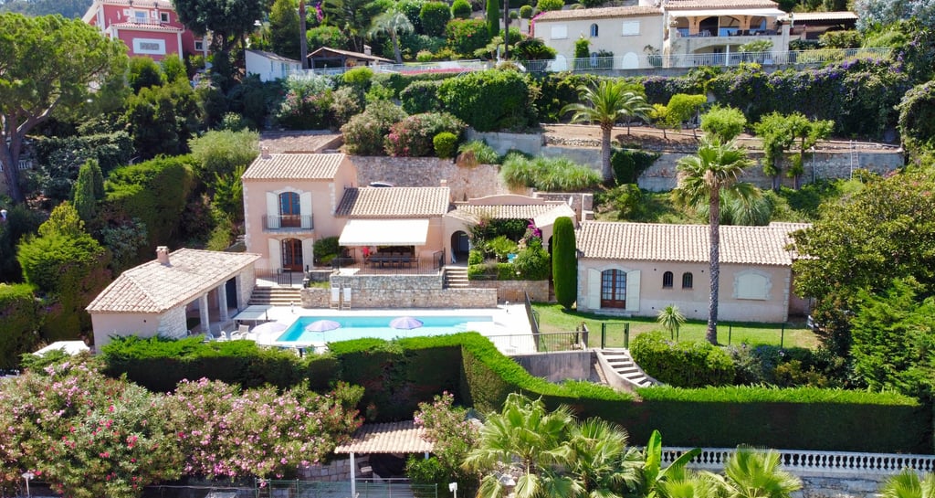 Vue aérienne d'une villa méditerranéenne avec piscine, entourée de jardins et située sur une colline
