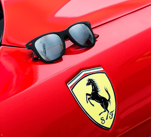 a pair of sunglasses and sunglasses on a red car