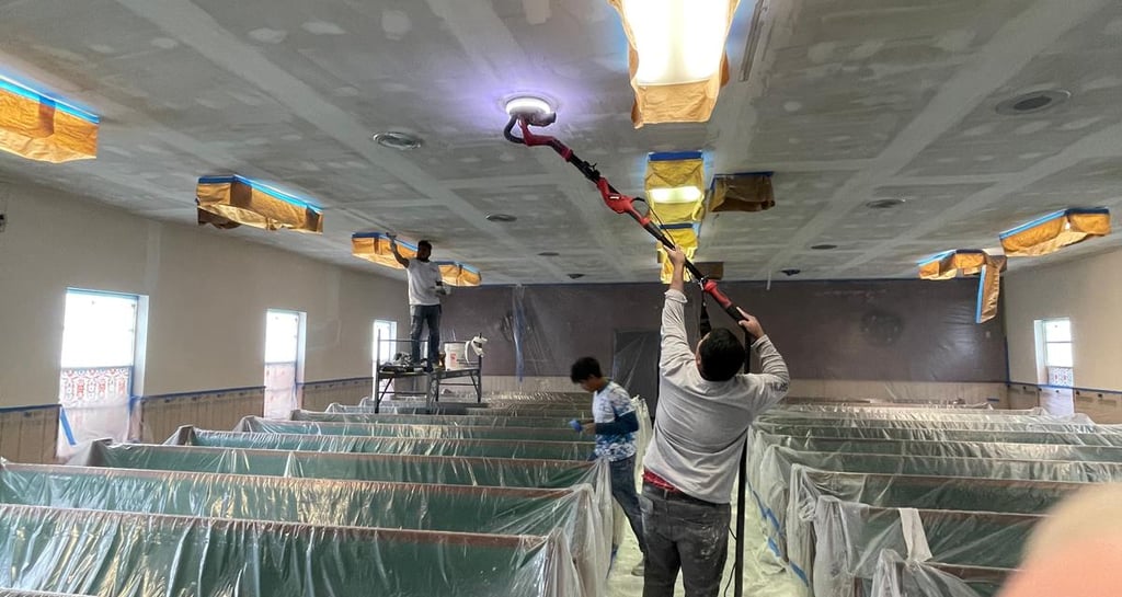 a man is painting a ceiling in a room 