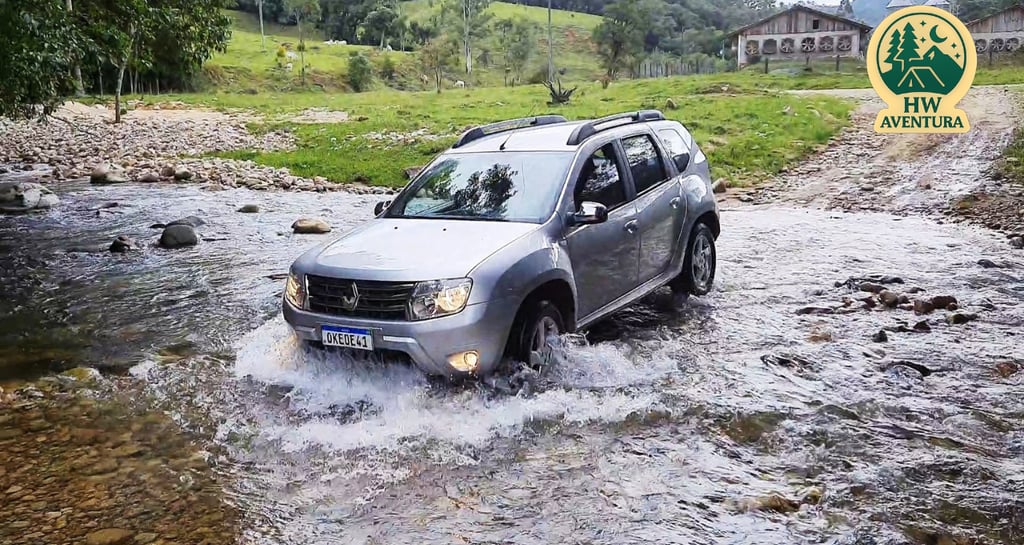 Renault Duster atravessando rio com pedras durante aventura outdoor em família