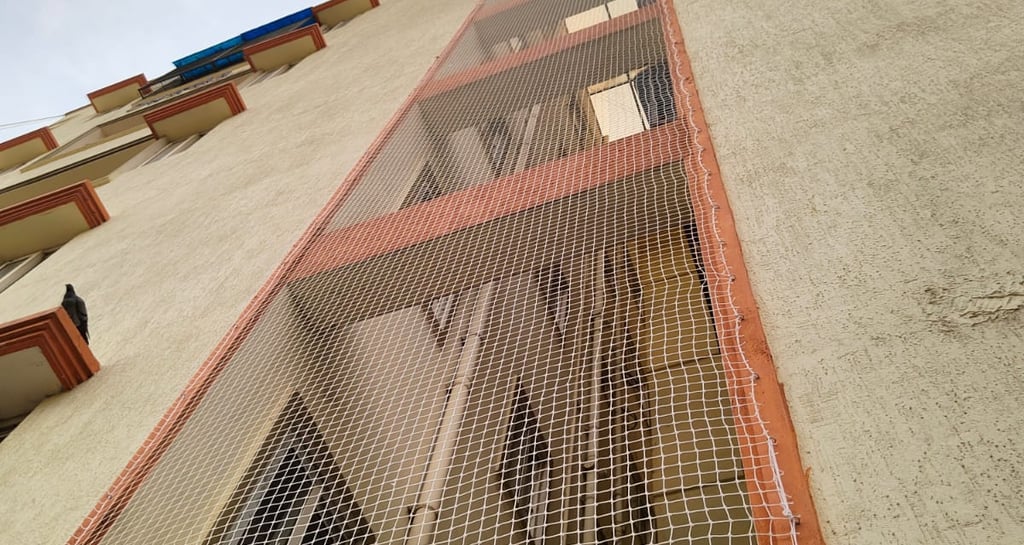 Close-up of a sturdy pigeon net securely fitted on a T Nagar balcony.
