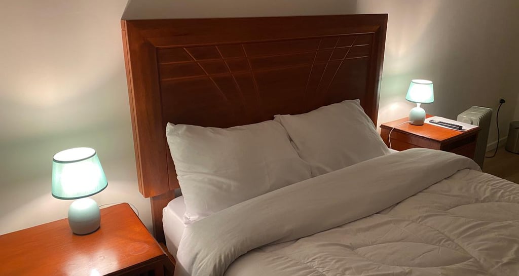 Cabecera de cama con iluminación cálida en hotel hospedaje en Huayllay Cerro de Pasco