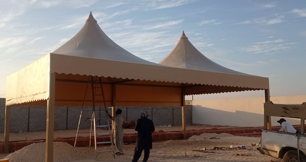 مظلات سيارات قماش PVC في الرياض بتصميم هرمي أنيق، توفر حماية قوية من الشمس ومناسبة للمواقف الخارجية.