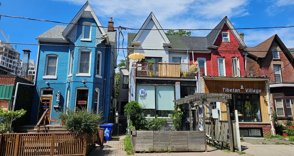 Colorful Victorian row houses featuring local businesses and shops in vibrant Toronto neighborhood.