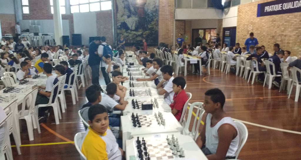 varias crianças e jovens jogando xadrez no evento intercolegial no rio de janeiro