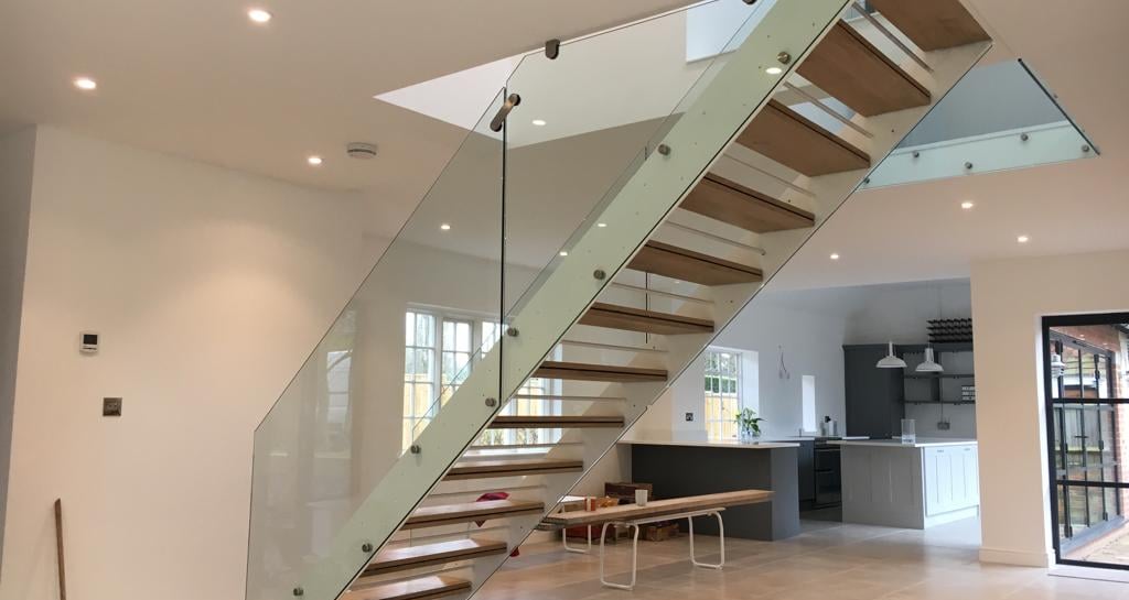 a beautiful staircase casement with a glass railing