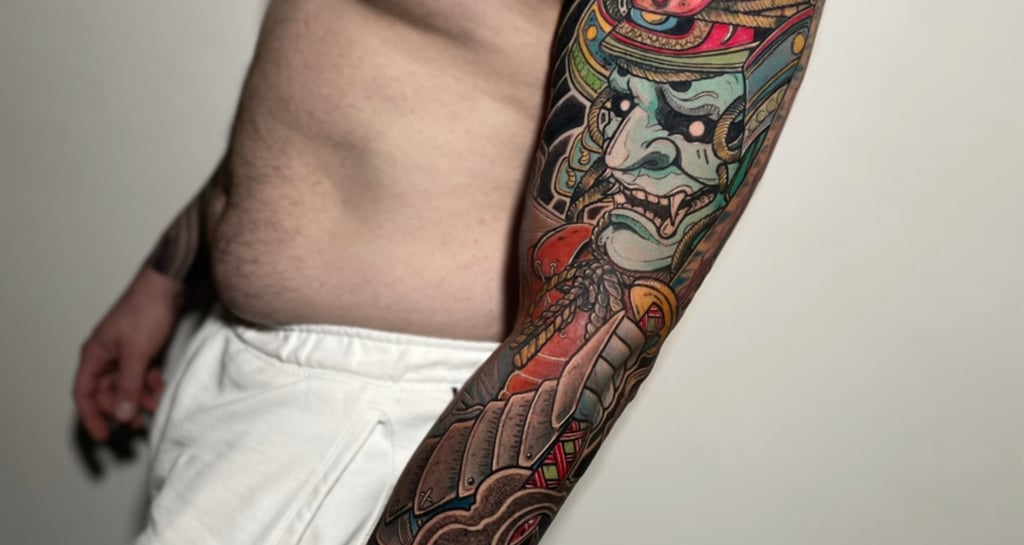 Tatuaggio a maniche lunghe in stile giapponese con una maschera di samurai eseguito da Horidoku 