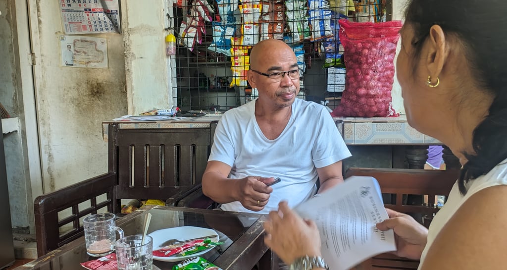 "A consultant explaining an interview questionnaire to a common man"