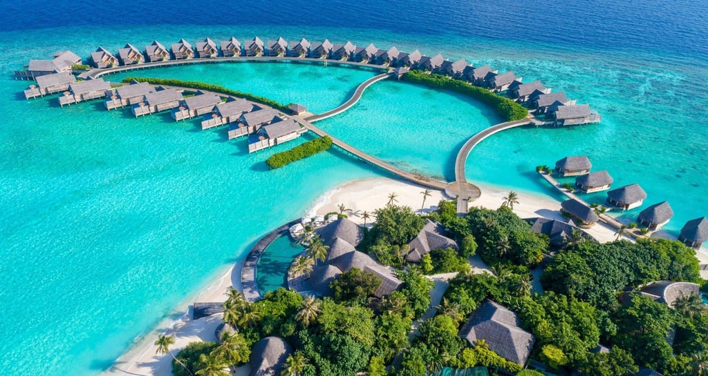 Overwater villas in the Maldives with clear blue lagoon and tropical scenery.